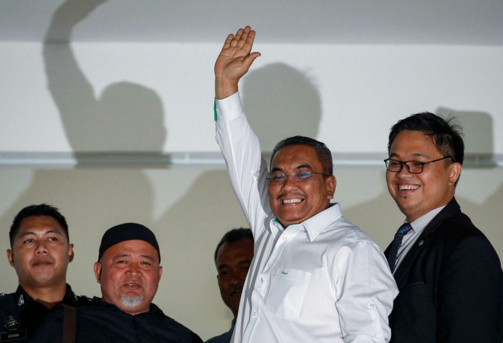 Muhammad Sanusi Md Nor melambai kepada pihak wartawan dan media sewaktu beliau meninggalkan perkarangan mahkamah di Gombak.